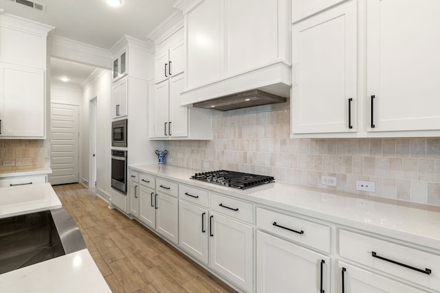 6523 Poplar Meadow Ln, Katy, TX 77493 - kitchen featuring stainless steel appliances, white cabinets, light countertops, light wood-type flooring, and ornamental molding