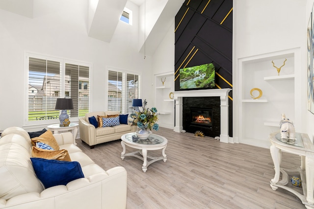 6523 Poplar Meadow Ln, Katy, TX 77493 - living area with a high ceiling, a large fireplace, built in shelves, and light wood-type flooring