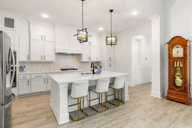 6523 Poplar Meadow Ln, Katy, TX 77493 - kitchen featuring custom exhaust hood, stainless steel refrigerator with ice dispenser, gas cooktop, backsplash, and light countertops