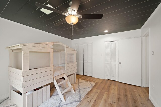 15722 Falmouth Dr, Houston, TX 77059 - unfurnished bedroom featuring multiple closets, wood finished floors, wooden ceiling, and a ceiling fan