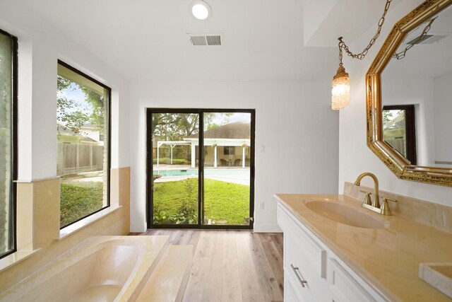 15722 Falmouth Dr, Houston, TX 77059 - full bath with double vanity, a tub to relax in, and wood finished floors