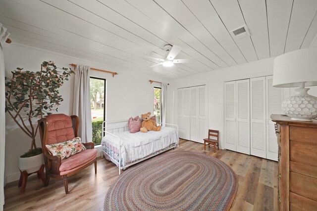 15722 Falmouth Dr, Houston, TX 77059 - bedroom featuring two closets, light wood finished floors, a ceiling fan, and wood ceiling