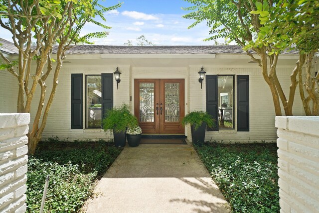15722 Falmouth Dr, Houston, TX 77059 - view of exterior entry with french doors, brick siding, and a shingled roof