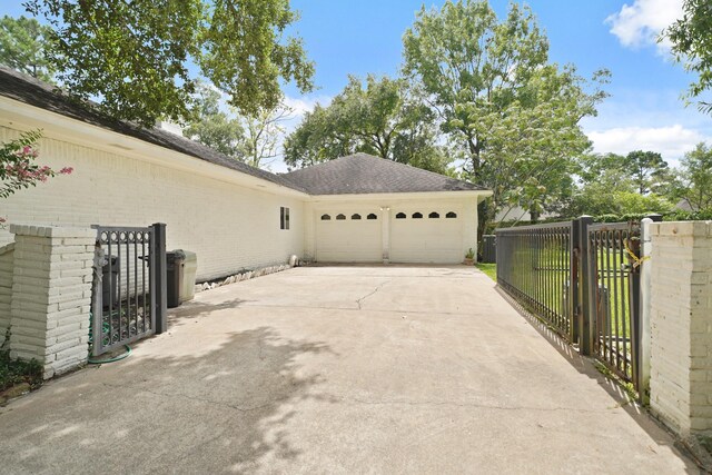 15722 Falmouth Dr, Houston, TX 77059 - view of side of home with an attached garage, concrete driveway, brick siding, and roof with shingles