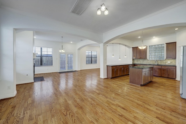 7539 Highmeadow, Houston, TX 77063 - kitchen with open floor plan, a chandelier, a kitchen island, dark countertops, and crown molding