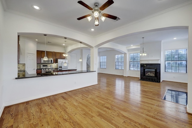 7539 Highmeadow, Houston, TX 77063 - unfurnished living room featuring ceiling fan, light wood-type flooring, arched walkways, a tile fireplace, and recessed lighting