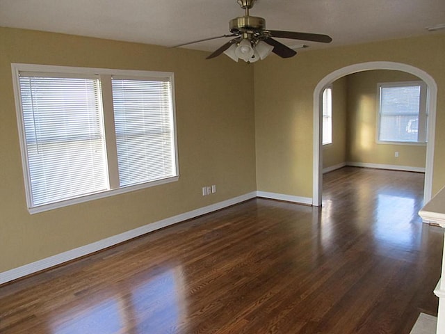 4911 Delano St, Houston, TX 77004 - empty room featuring arched walkways, a ceiling fan, and dark wood-type flooring