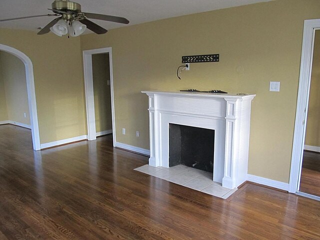 4911 Delano St, Houston, TX 77004 - unfurnished living room featuring wood finished floors, a ceiling fan, arched walkways, and a fireplace with flush hearth