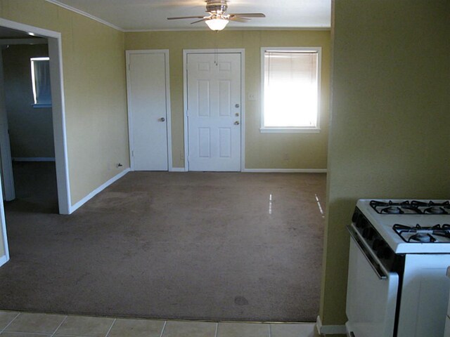 4911 Delano St, Houston, TX 77004 - kitchen featuring white range with gas stovetop, ceiling fan, ornamental molding, and carpet flooring