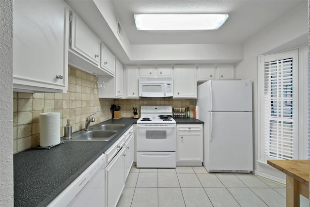 2002 Gentryside Dr Unit 117, Houston, TX 77077 - kitchen with white appliances, dark countertops, white cabinets, light tile patterned floors, and decorative backsplash