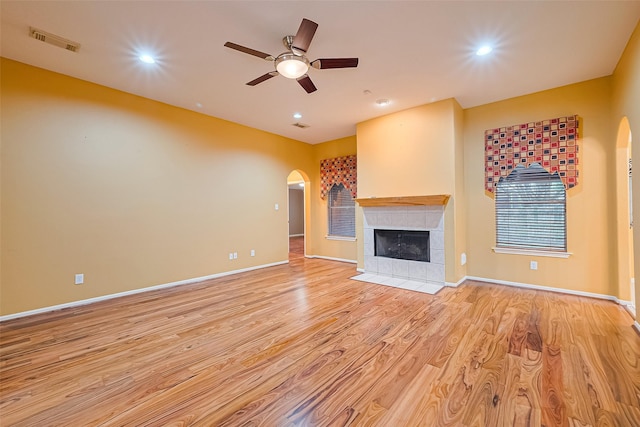3803 Doveswood Cir, Needville, TX 77461 - unfurnished living room featuring arched walkways, ceiling fan, light wood-style floors, a fireplace, and recessed lighting