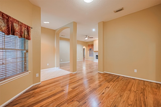 3803 Doveswood Cir, Needville, TX 77461 - spare room featuring arched walkways, light wood-style flooring, and a ceiling fan