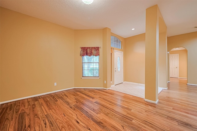 3803 Doveswood Cir, Needville, TX 77461 - entryway with arched walkways, light wood-style flooring, and a textured ceiling