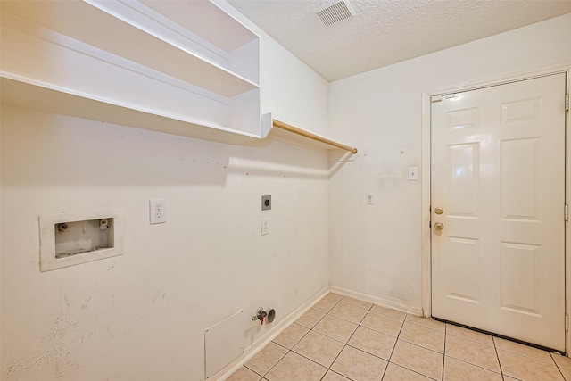 3803 Doveswood Cir, Needville, TX 77461 - laundry room with hookup for a washing machine, hookup for an electric dryer, light tile patterned flooring, gas dryer hookup, and a textured ceiling