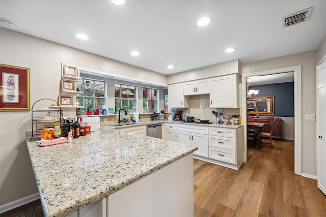 3101 Yost Blvd, Pearland, TX 77581 - kitchen featuring a peninsula, light wood-style floors, white cabinetry, light stone countertops, and a chandelier