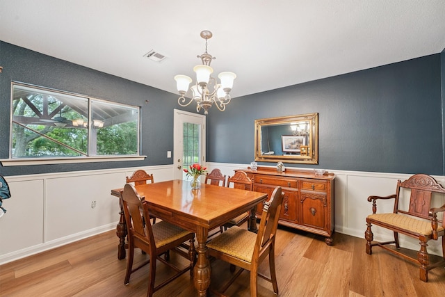 3101 Yost Blvd, Pearland, TX 77581 - dining area featuring a chandelier, a wainscoted wall, and light wood-type flooring