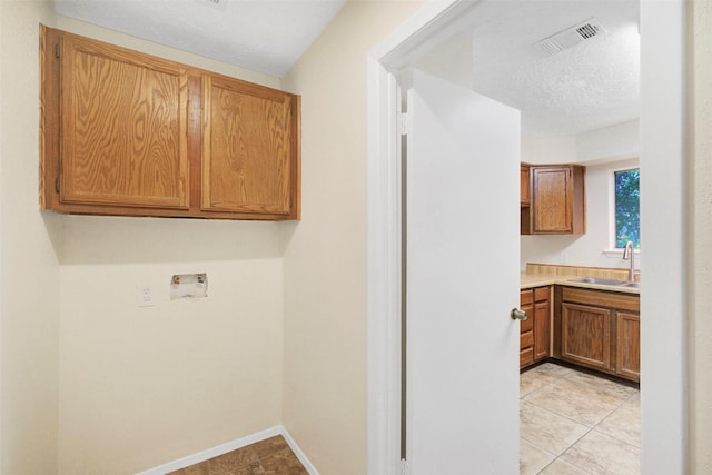 10314 Paintbrush Ln, Sugar Land, TX 77498 - laundry area with hookup for a washing machine, cabinet space, and light tile patterned floors