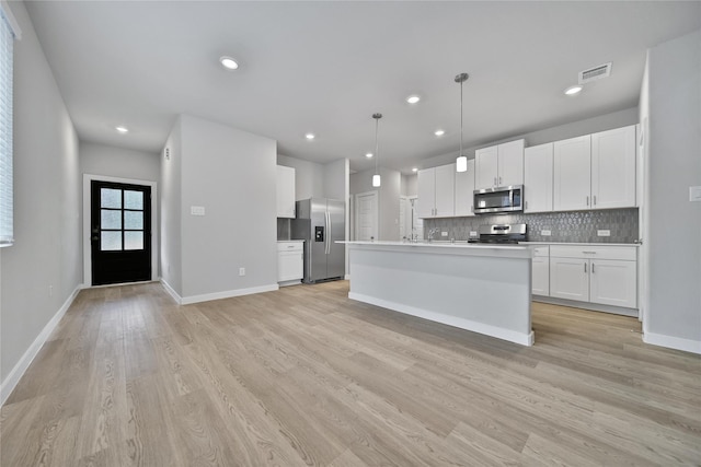 6609 Lahna Oak Dr, Conroe, TX 77304 - kitchen featuring appliances with stainless steel finishes, light wood-style flooring, backsplash, white cabinets, and recessed lighting
