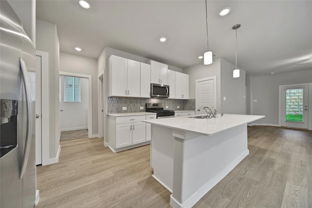 6609 Lahna Oak Dr, Conroe, TX 77304 - kitchen with stainless steel appliances, white cabinetry, light countertops, decorative backsplash, and recessed lighting