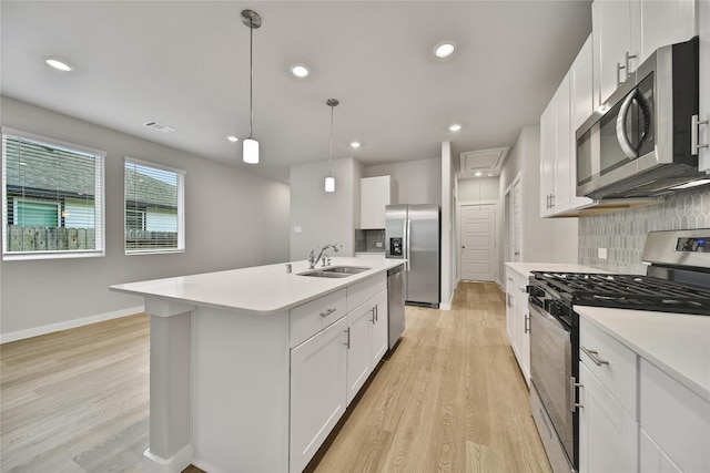 6609 Lahna Oak Dr, Conroe, TX 77304 - kitchen featuring stainless steel appliances, light wood-style flooring, backsplash, light countertops, and recessed lighting