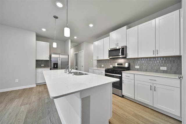6609 Lahna Oak Dr, Conroe, TX 77304 - kitchen featuring stainless steel appliances, light wood-style flooring, light countertops, a center island with sink, and recessed lighting