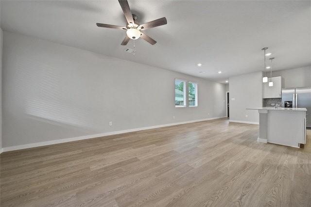 6609 Lahna Oak Dr, Conroe, TX 77304 - unfurnished living room with light wood-style flooring, a ceiling fan, and recessed lighting