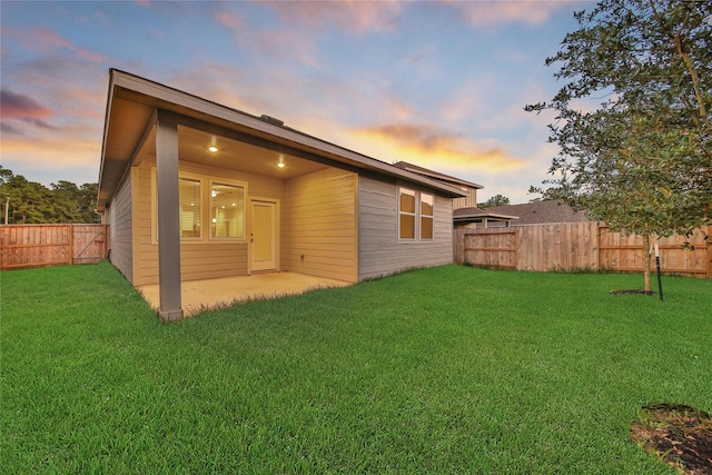 6609 Lahna Oak Dr, Conroe, TX 77304 - back of house at dusk with a fenced backyard and a patio
