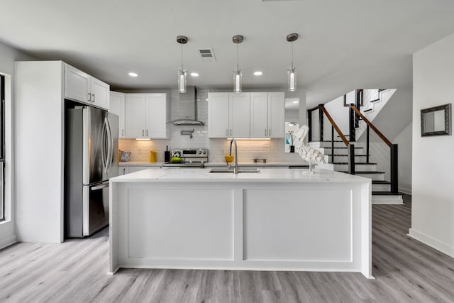 118 Hickory Pnes, Livingston, TX 77351 - kitchen featuring stainless steel appliances, wall chimney range hood, light wood-style flooring, decorative backsplash, and recessed lighting
