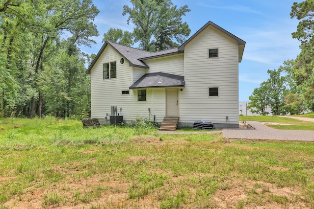 118 Hickory Pnes, Livingston, TX 77351 - rear view of property featuring a shingled roof and entry steps
