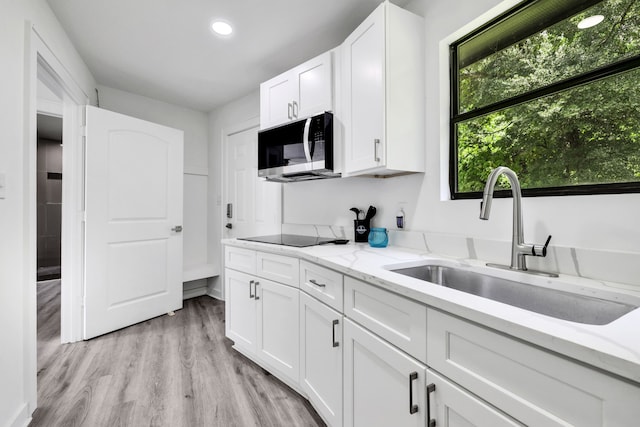 118 Hickory Pnes, Livingston, TX 77351 - kitchen featuring stainless steel microwave, black electric stovetop, white cabinetry, recessed lighting, and light wood-style floors