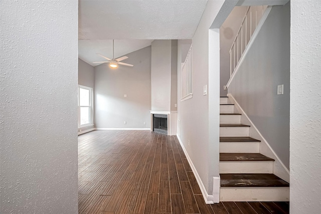10318 Rockcrest Dr, Houston, TX 77041 - stairway with a ceiling fan, wood finished floors, a fireplace, a textured wall, and high vaulted ceiling