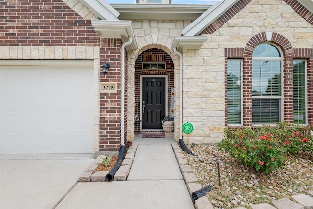 30119 Saw Oaks Dr, Magnolia, TX 77355 - entrance to property featuring a garage, stone siding, driveway, and brick siding