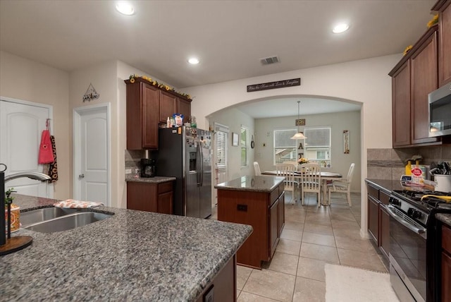 30119 Saw Oaks Dr, Magnolia, TX 77355 - kitchen with stainless steel appliances, arched walkways, a center island, decorative backsplash, and recessed lighting