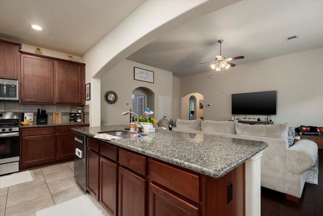 30119 Saw Oaks Dr, Magnolia, TX 77355 - kitchen featuring stainless steel appliances, a ceiling fan, arched walkways, stone counters, and recessed lighting