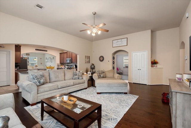 30119 Saw Oaks Dr, Magnolia, TX 77355 - living room with arched walkways, ceiling fan, and dark wood-style floors