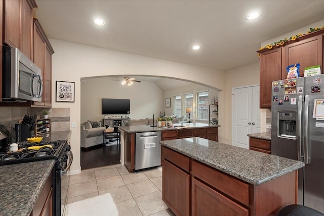 30119 Saw Oaks Dr, Magnolia, TX 77355 - kitchen featuring stainless steel appliances, a center island, open floor plan, arched walkways, and ceiling fan