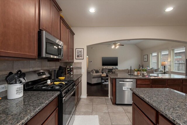 30119 Saw Oaks Dr, Magnolia, TX 77355 - kitchen featuring stainless steel appliances, open floor plan, a ceiling fan, decorative backsplash, and arched walkways