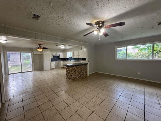 7717 Bigwood St, Houston, TX 77016 - unfurnished living room with a ceiling fan, light tile patterned floors, and a textured ceiling