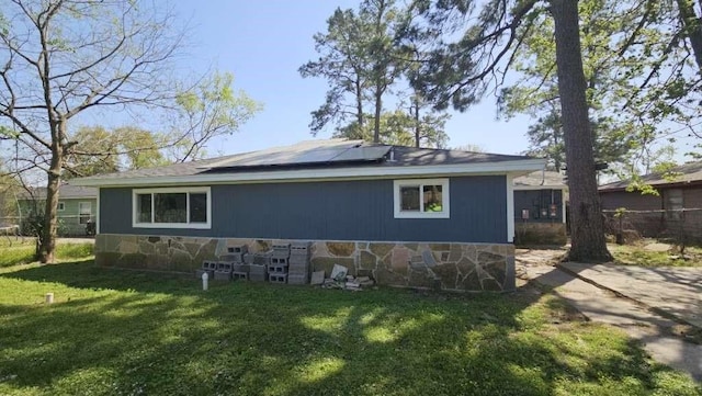 7717 Bigwood St, Houston, TX 77016 - rear view of house with solar panels and stone siding