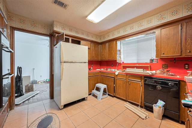 25107 Broughton St, Spring, TX 77373 - kitchen with freestanding refrigerator, dishwasher, brown cabinets, double wall oven, and a textured ceiling