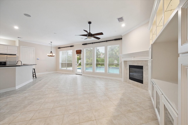 15411 Driftwood Oak Ct, Houston, TX 77059 - unfurnished living room with a fireplace, ceiling fan, ornamental molding, light tile patterned floors, and a chandelier