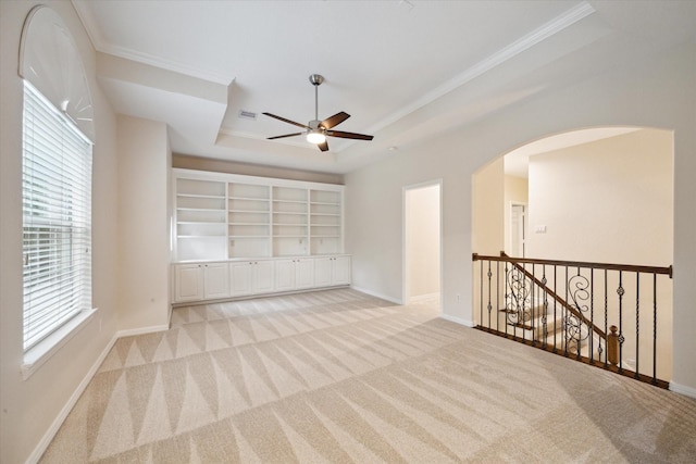 15411 Driftwood Oak Ct, Houston, TX 77059 - empty room with light colored carpet, ornamental molding, a ceiling fan, arched walkways, and a tray ceiling