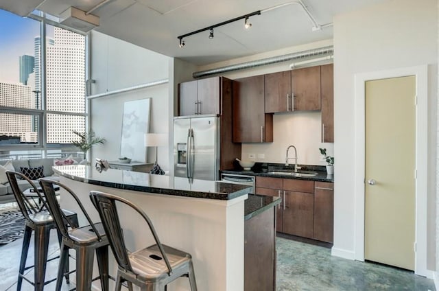 2000 Bagby St Unit 9420, Houston, TX 77002 - kitchen featuring stainless steel appliances, a breakfast bar area, a center island, finished concrete flooring, and dark stone counters