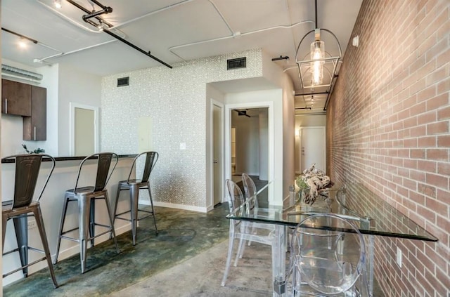2000 Bagby St Unit 9420, Houston, TX 77002 - kitchen featuring concrete flooring, dark brown cabinetry, brick wall, a breakfast bar, and an accent wall