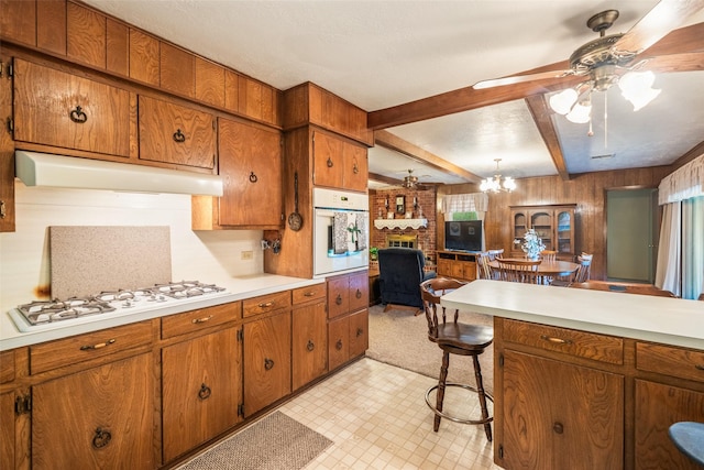 91 E Post Oak Ln, Shepherd, TX 77371 - kitchen with white appliances, brown cabinetry, light countertops, and beamed ceiling