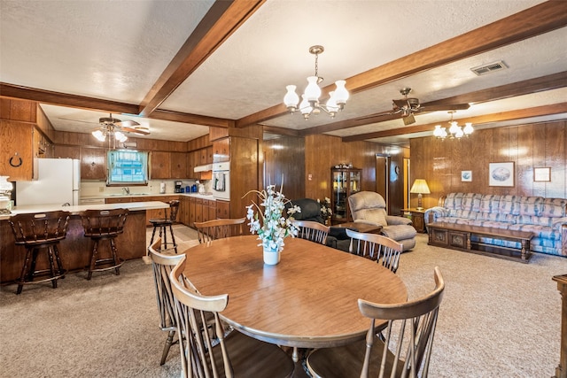 91 E Post Oak Ln, Shepherd, TX 77371 - dining room featuring light colored carpet, a chandelier, ceiling fan, wooden walls, and beamed ceiling