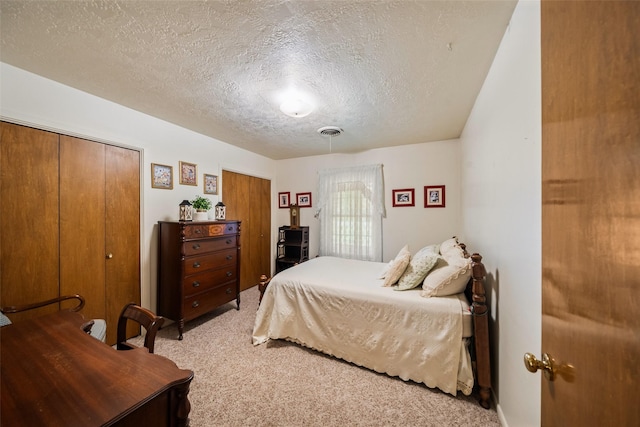 91 E Post Oak Ln, Shepherd, TX 77371 - bedroom featuring light colored carpet, two closets, and a textured ceiling