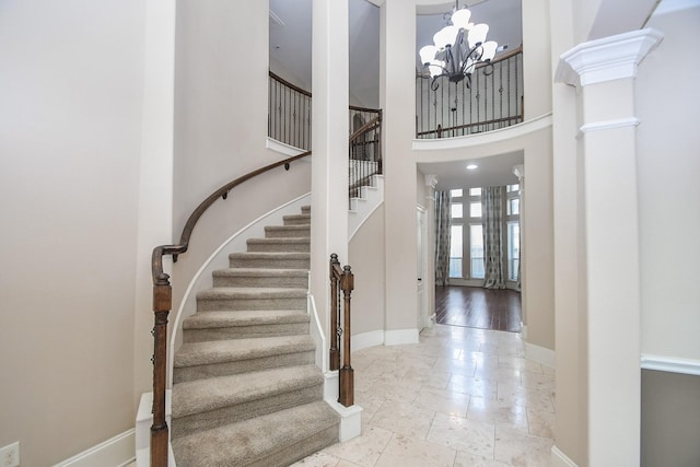 6034 Gracys Landing Ln, Katy, TX 77494 - stairway featuring a chandelier, a towering ceiling, and stone tile floors