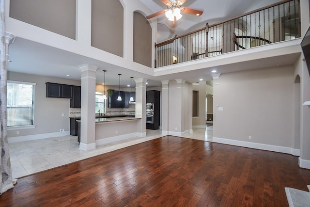 6034 Gracys Landing Ln, Katy, TX 77494 - unfurnished living room featuring ceiling fan, light wood finished floors, healthy amount of natural light, recessed lighting, and ornate columns