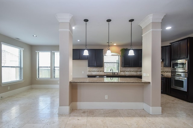 6034 Gracys Landing Ln, Katy, TX 77494 - kitchen with stainless steel appliances, light stone countertops, decorative backsplash, ornate columns, and recessed lighting